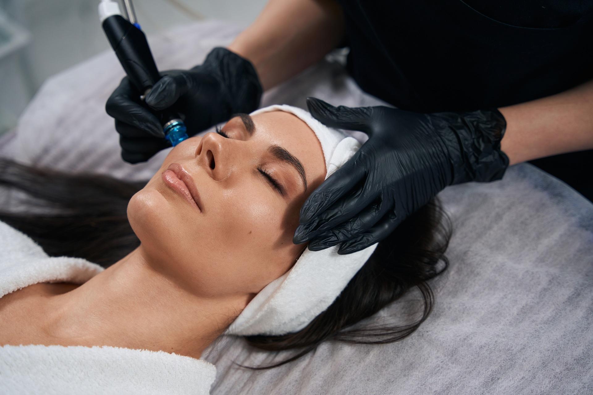 Kosmetikerin reinigt Gesicht einer Frau mit Gerät | Hydrafacial Behandlung